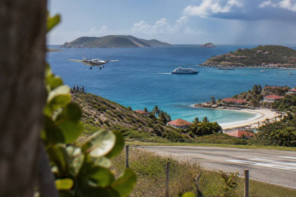 A ferry boat crossing open blue water between green Caribbean islands
