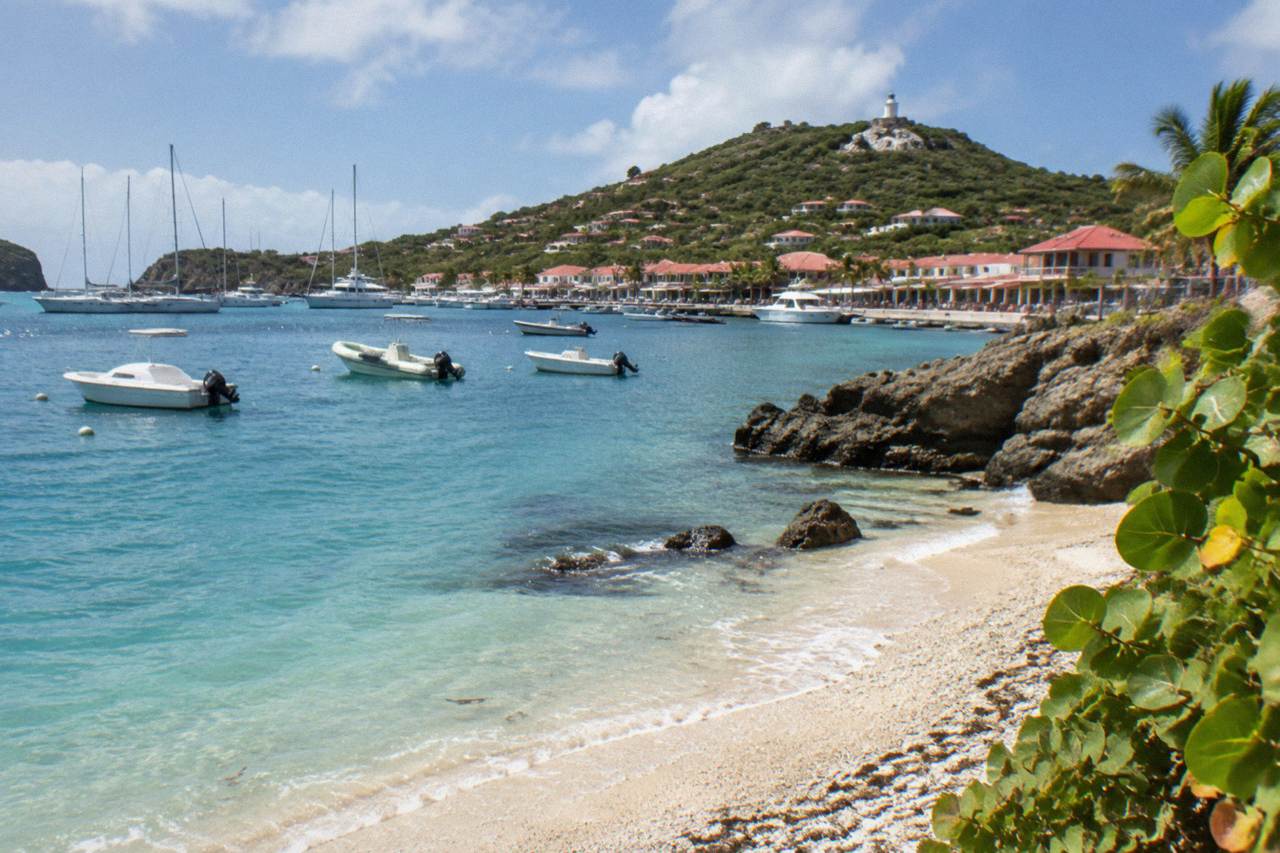 A small curved beach of broken shells beside rocky headlands close to Gustavia harbor in St Barts