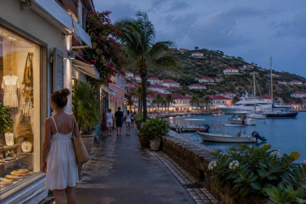 A visitor browsing boutique storefronts along a narrow street in Gustavia, St Barts