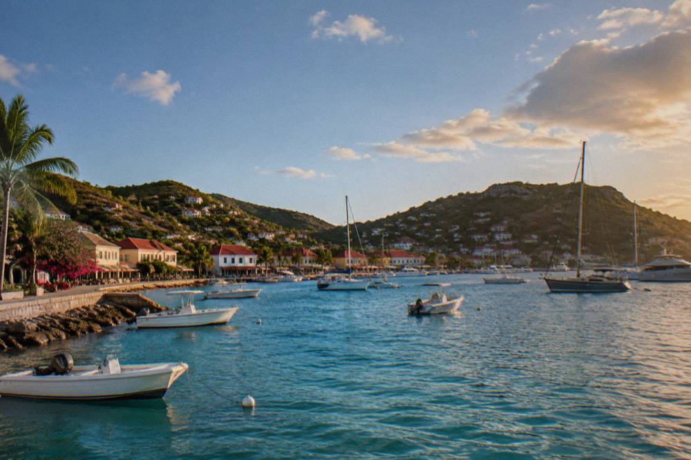 The waterfront of Gustavia with low buildings along the harbor and boats at anchor