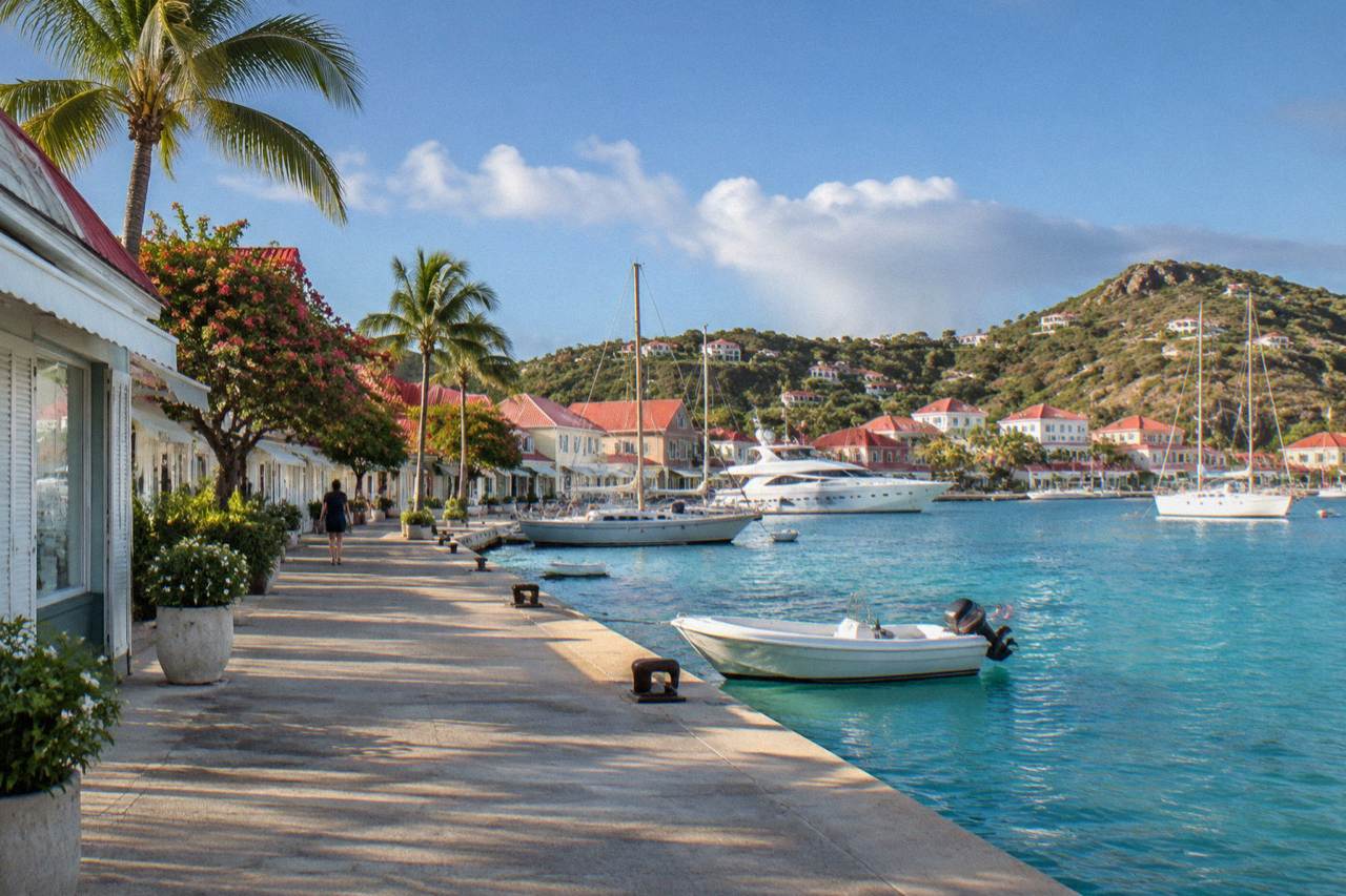 Luxury boutique storefronts along a harbor street with yachts moored nearby