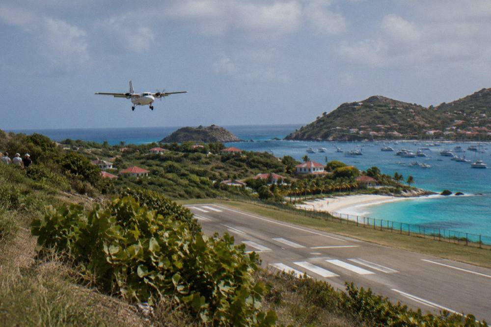 A small turboprop aircraft on the short runway at Gustaf III Airport in St Barts
