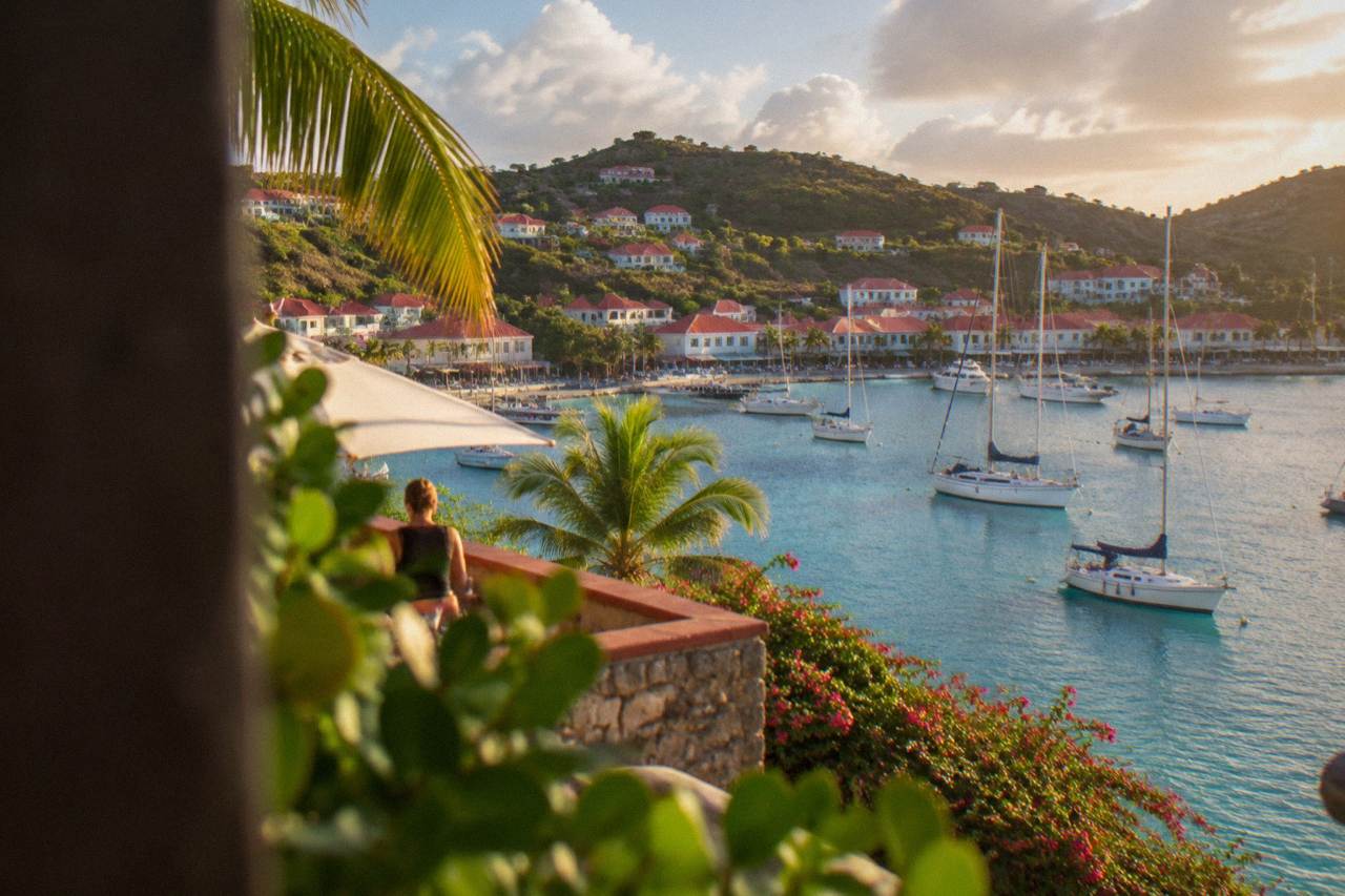 Sailboats anchored in turquoise water below the hills of St Barts