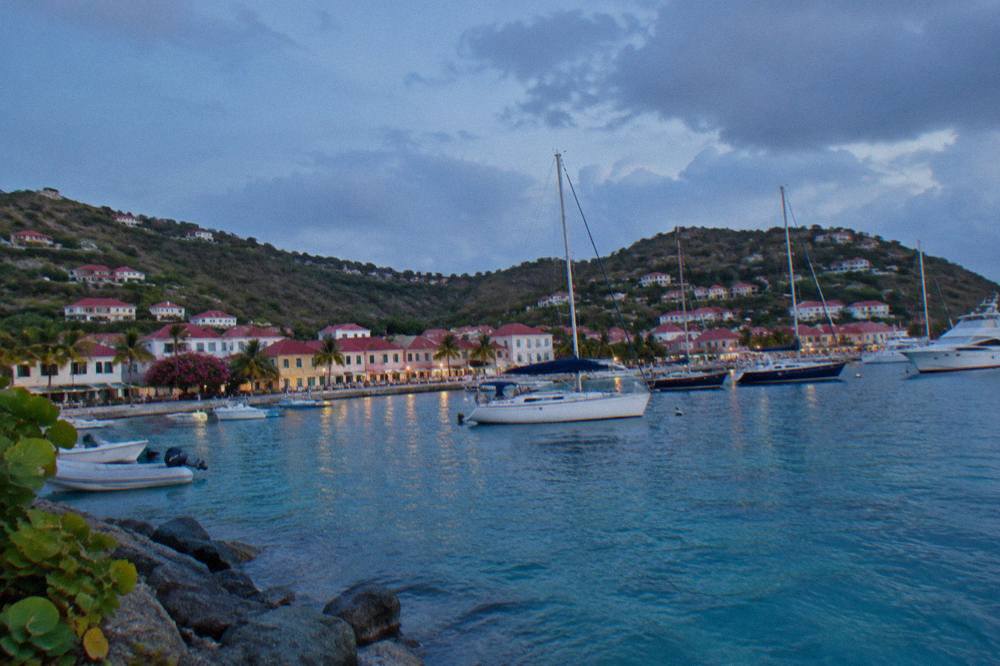 Turquoise water and green hills along the coastline of St Barts seen from the sea