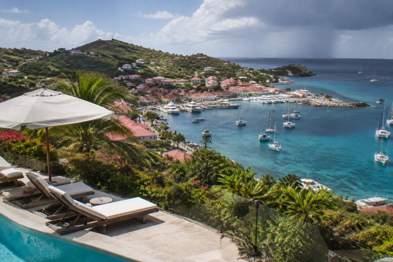 A hillside resort terrace overlooking a turquoise Caribbean bay on St Barts