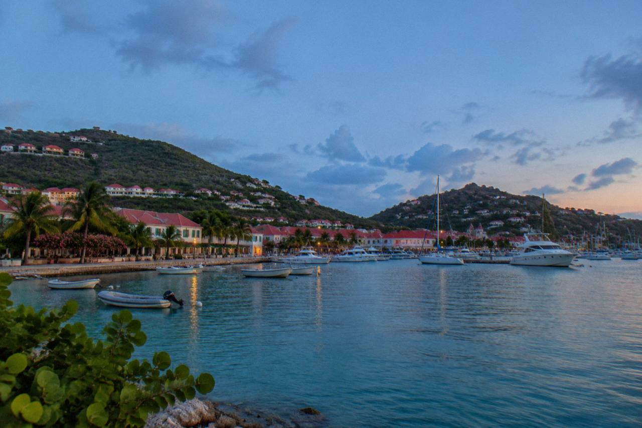 Hillside houses with red roofs above a turquoise bay on a small Caribbean island