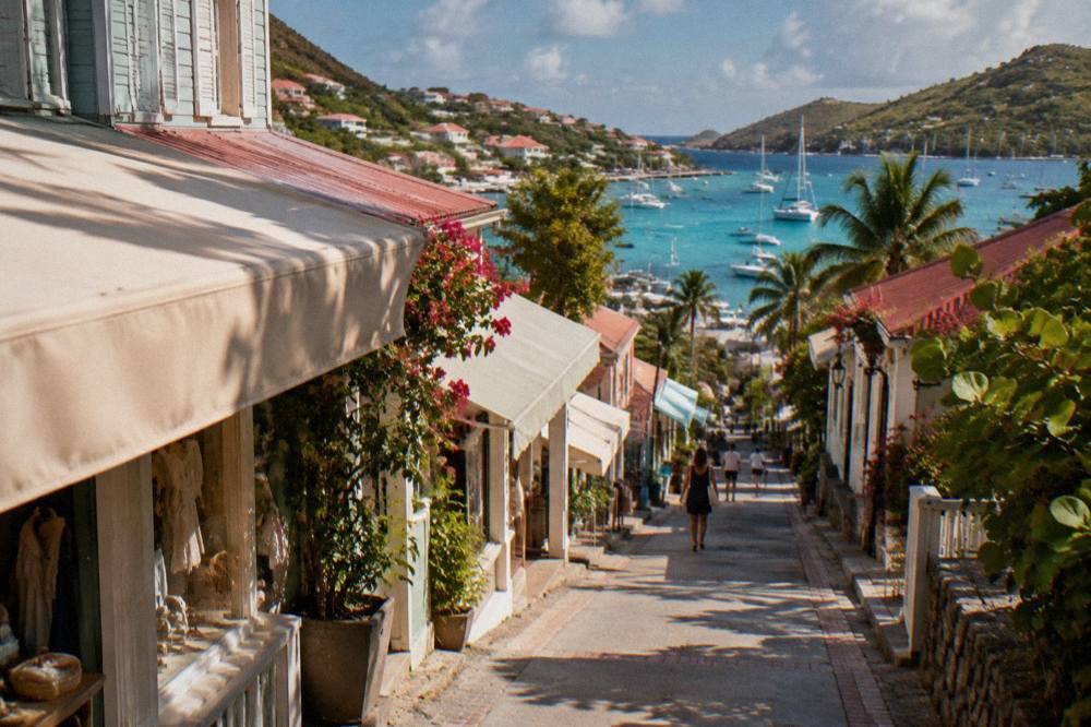 A shaded boutique awning on a narrow street rising behind the Gustavia harbor
