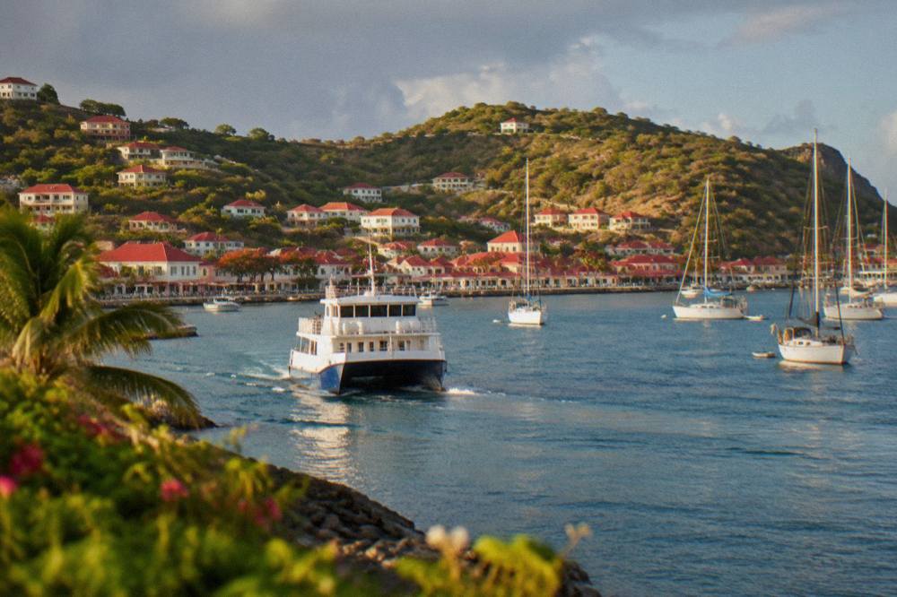 A ferry boat approaching the harbour at Gustavia in St Barts with anchored sailboats