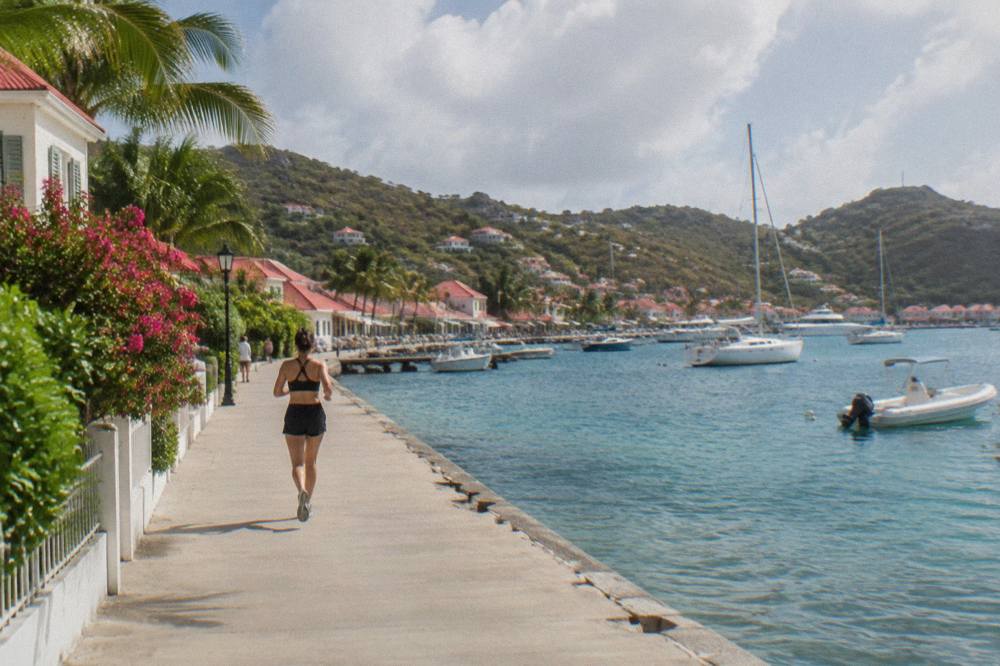 Sailboats anchored in a quiet bay on St Barts with green hills behind