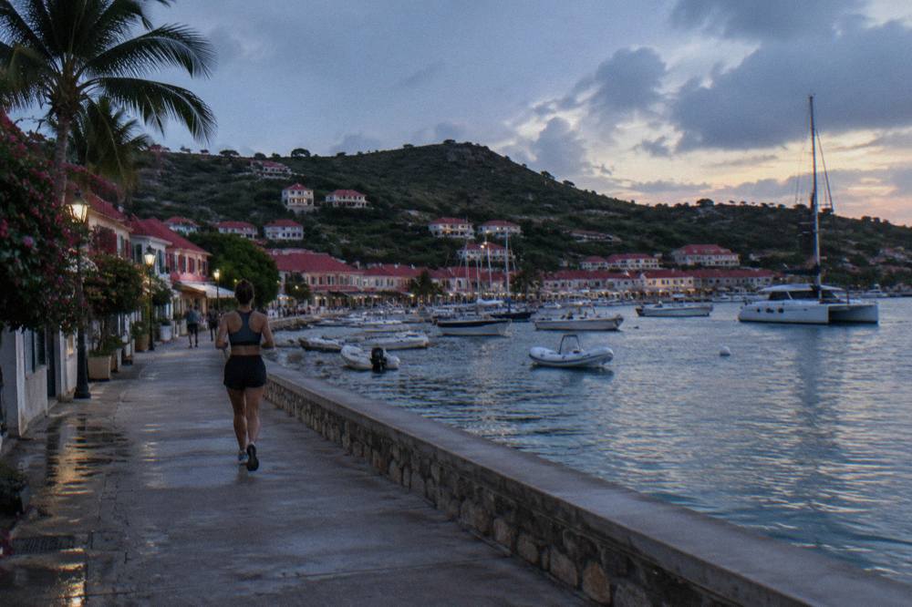 A catamaran anchored off a green hillside in a quiet Caribbean bay