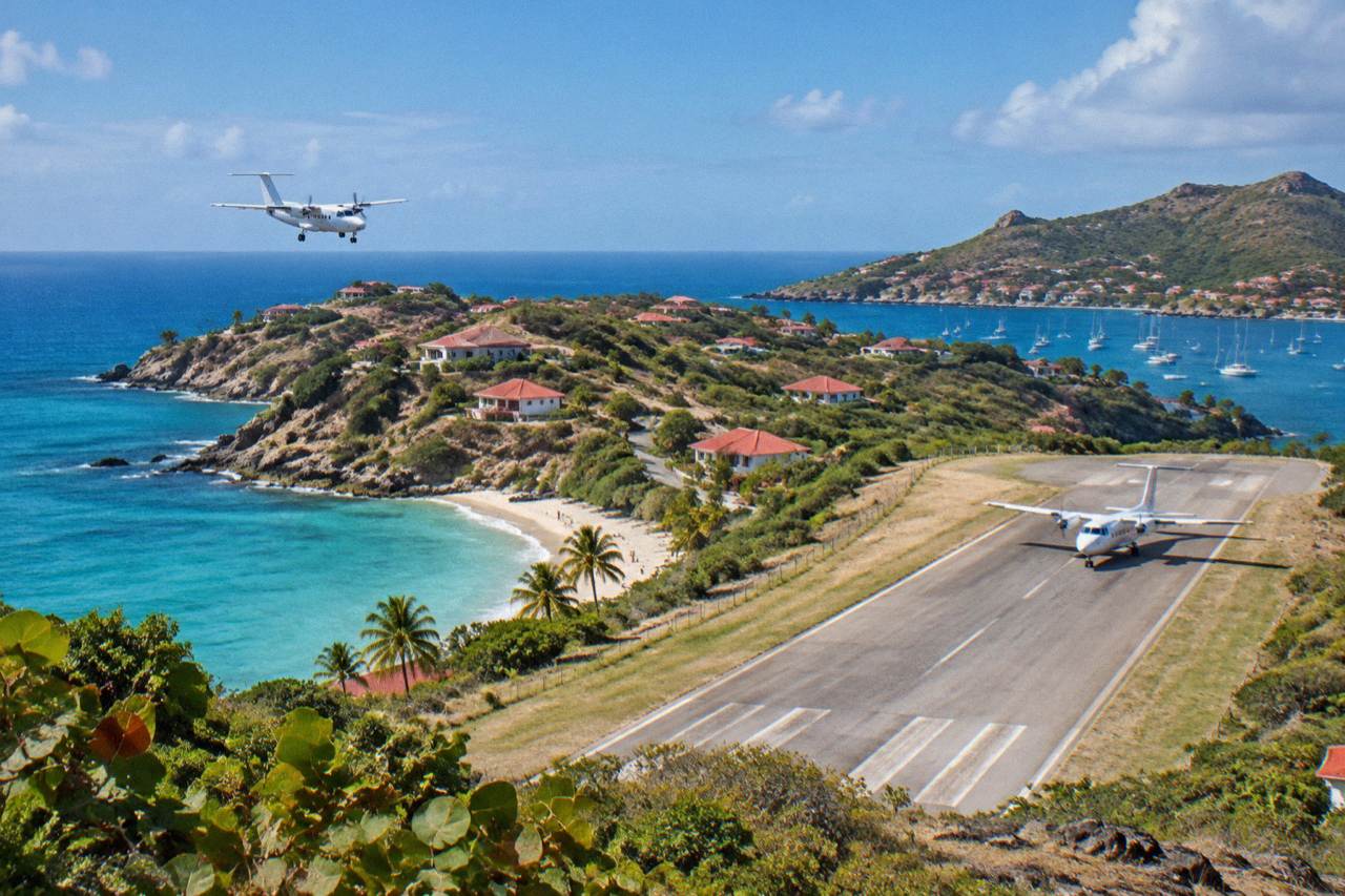 A small turboprop aircraft on the short runway at Gustaf III Airport in St Barts with hills and blue sea behind it