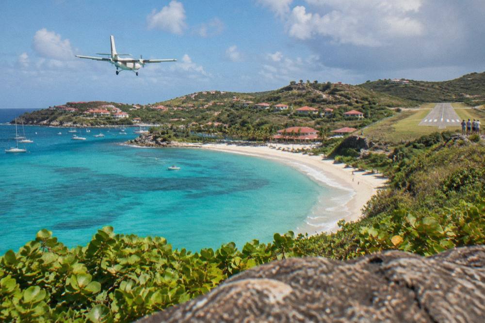 The hillside approach over turquoise water toward the beach at Saint-Jean in St Barts seen from above