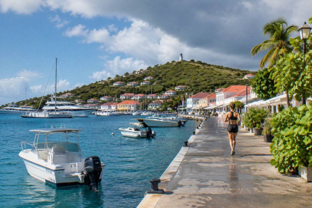White boats moored in Gustavia harbour with pastel facades along the waterfront