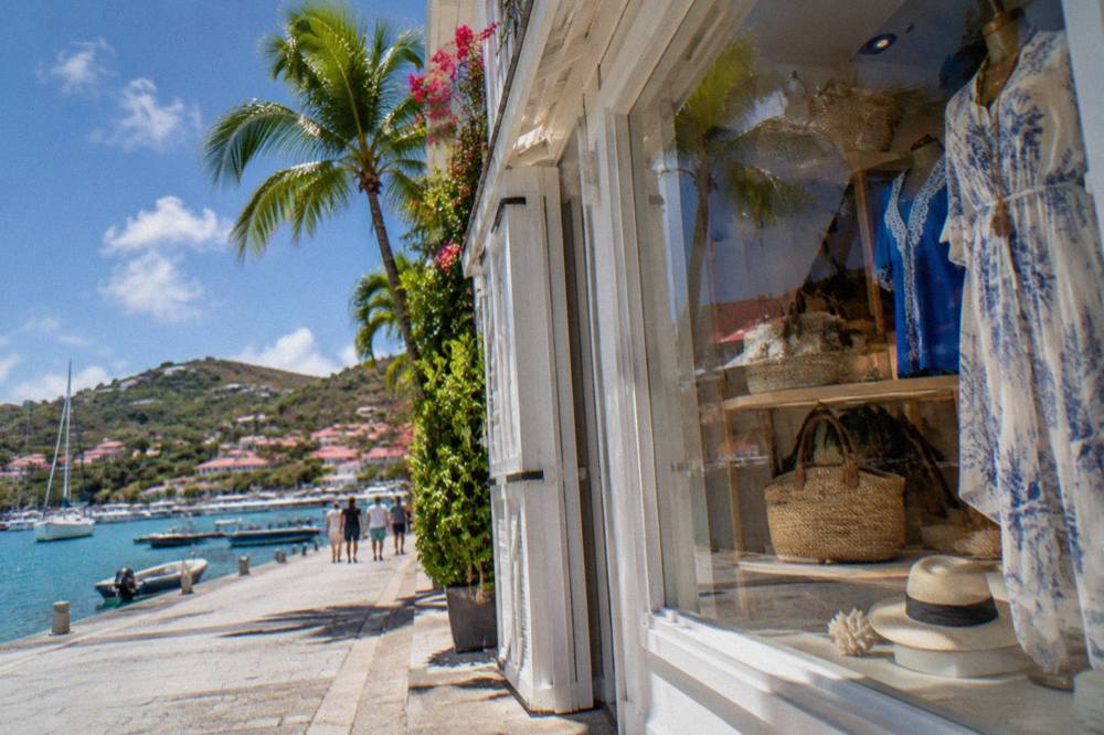 A display window with handbags and resort clothing on a sunny Gustavia street