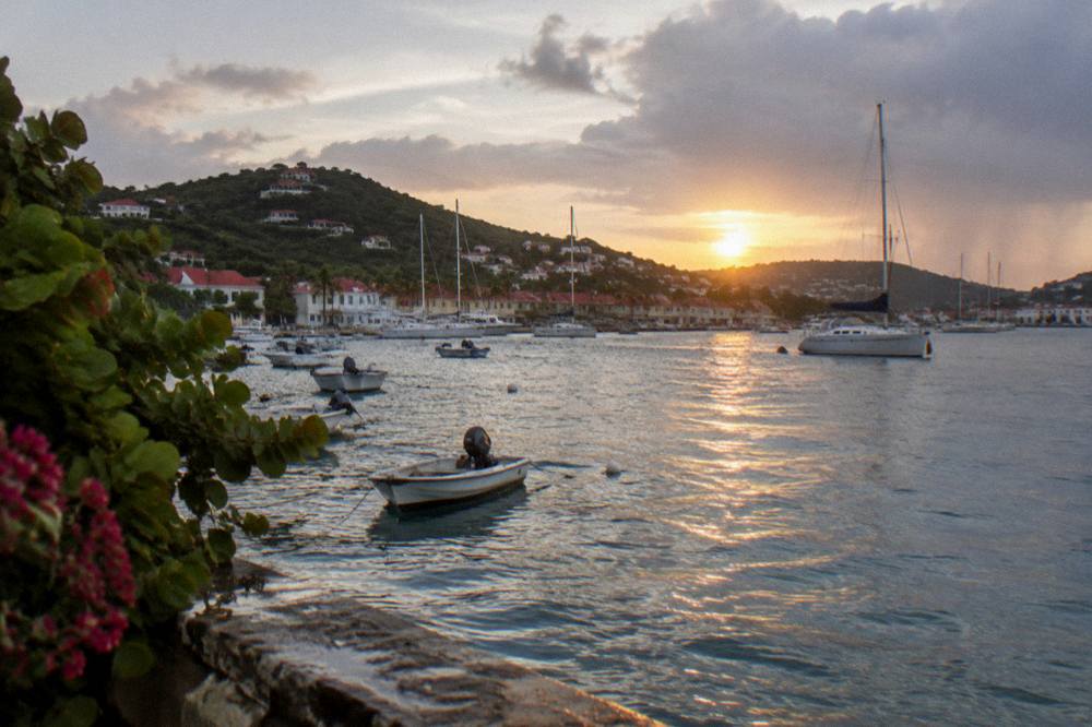 Sunset light over the harbour of Gustavia with yachts moored in the bay