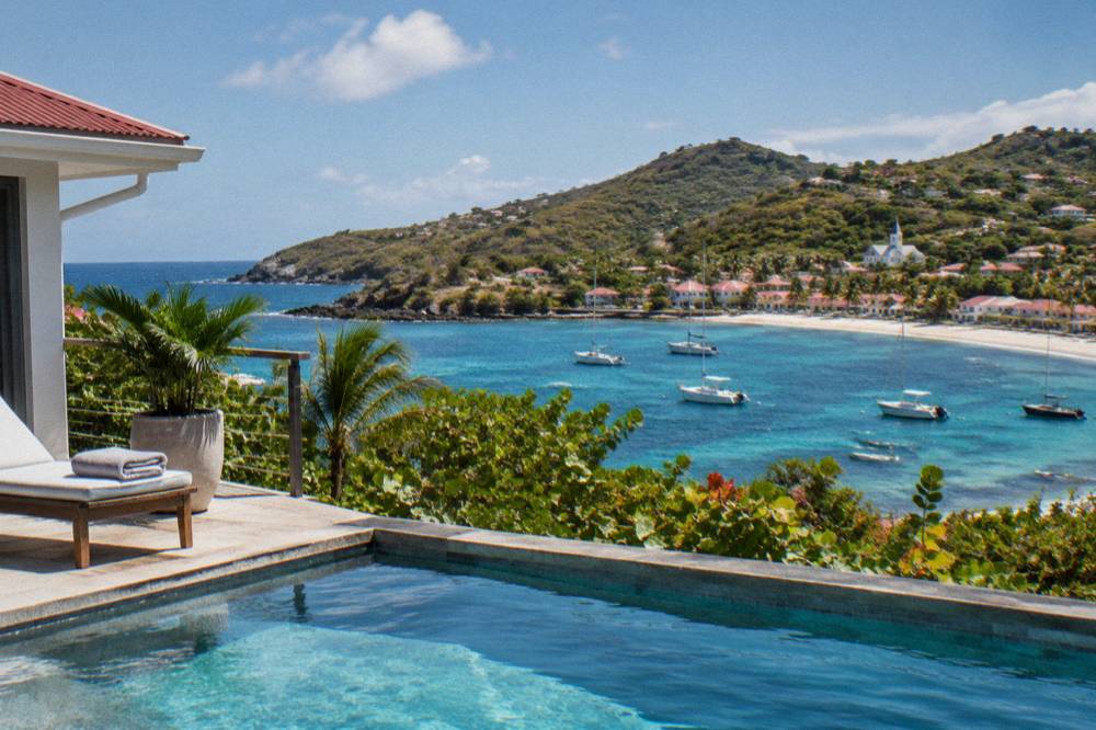 A hillside villa with a pool overlooking a Caribbean bay