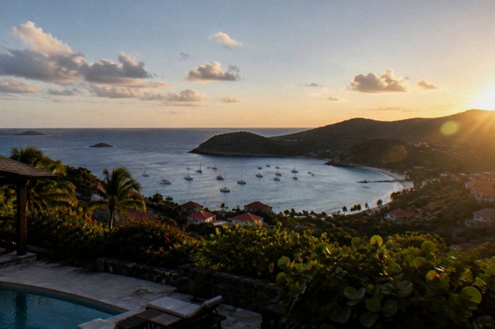 An evening view of a calm bay with darkening hills and a pale horizon