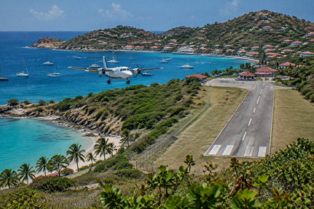 A small turboprop aircraft on the short runway at Gustaf III Airport in St Barts
