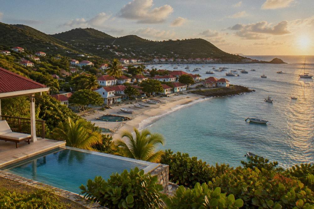 A hillside villa with a pool overlooking a Caribbean coastline at golden hour