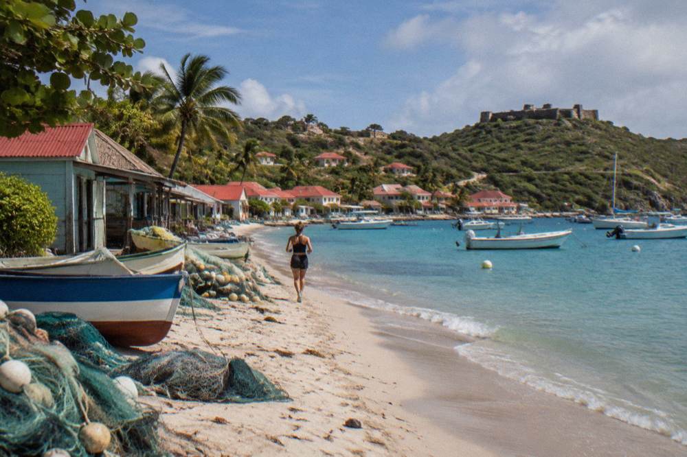 A stone fort ruin overlooking a Caribbean harbour with boats at anchor