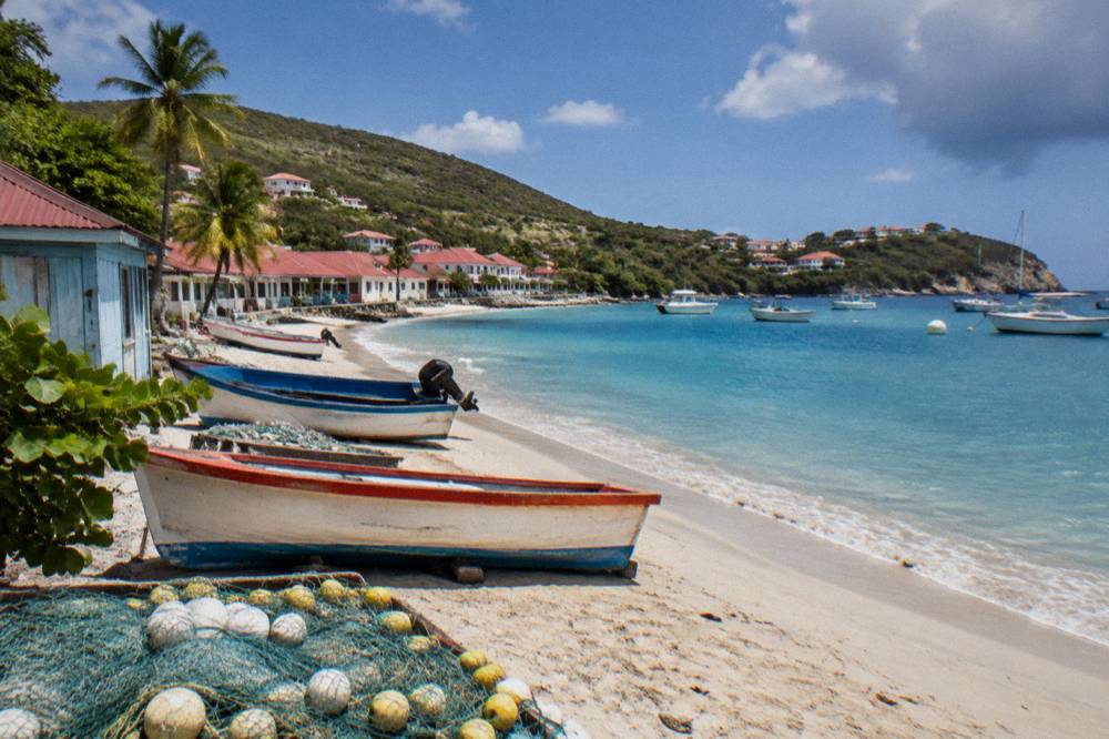 Sunlight over turquoise Caribbean water along a green coastline