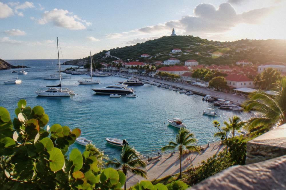 Small harbour with moored yachts and pastel waterfront buildings in morning light