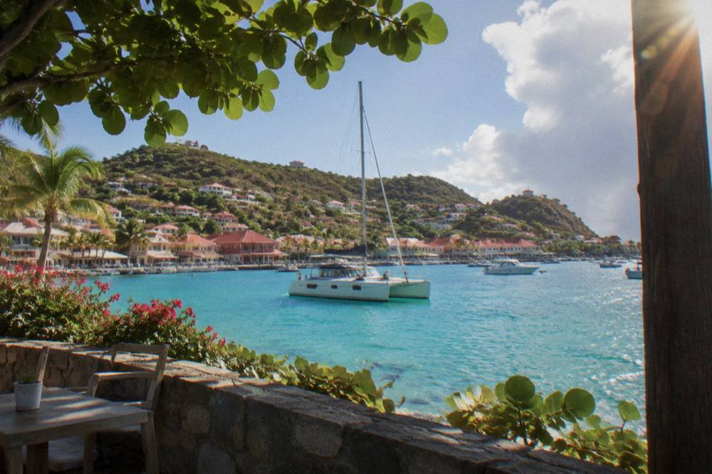 A sailing catamaran anchored in a turquoise bay on the coast of St Barts