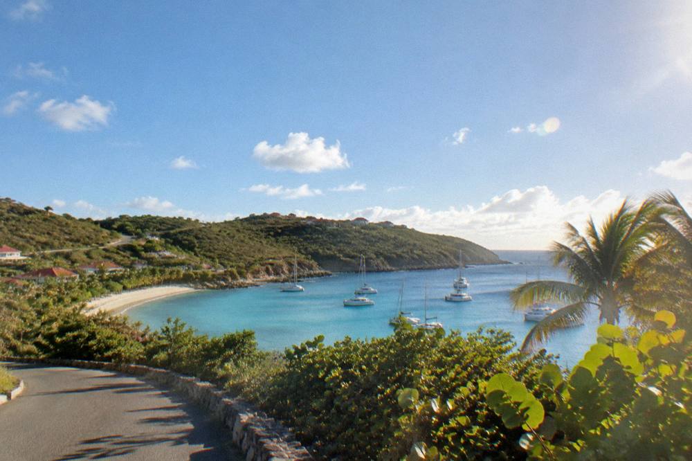 A narrow winding road with green hillsides on a small Caribbean island