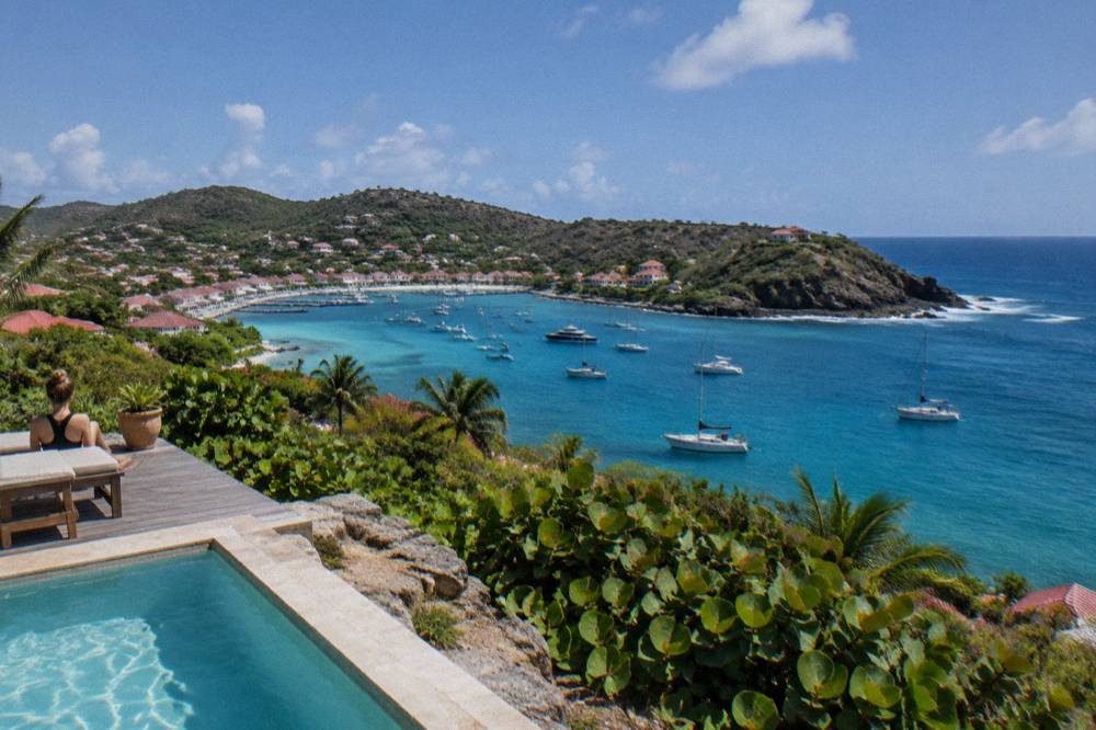 Villas with terraces set on a green hillside above the Caribbean Sea