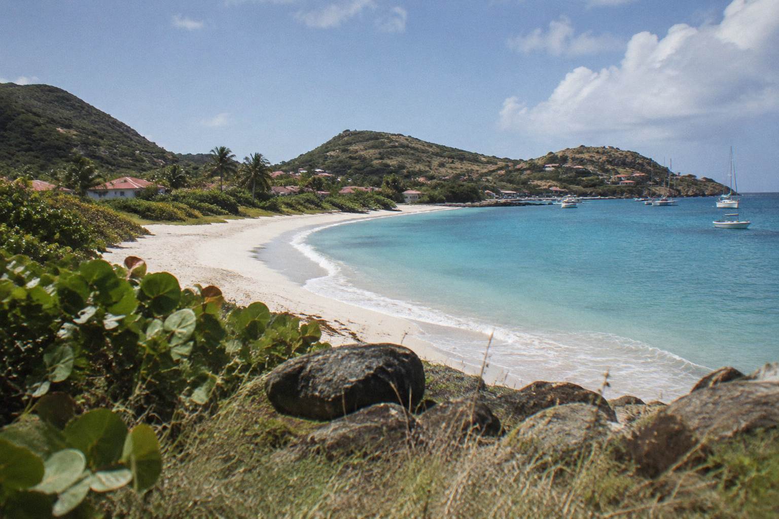Long open sand beach with dune grass and clear water
