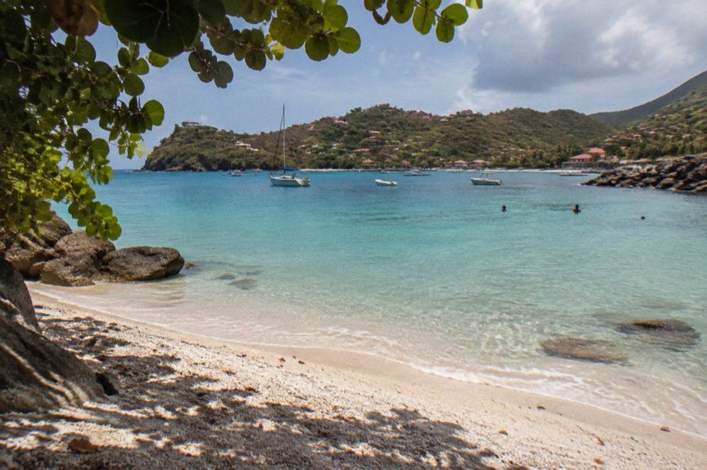 Small crescent beach of pale shell sand beside a town