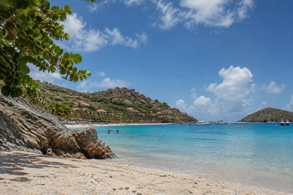 Golden evening light on the sand and rocky edges of Shell Beach near Gustavia
