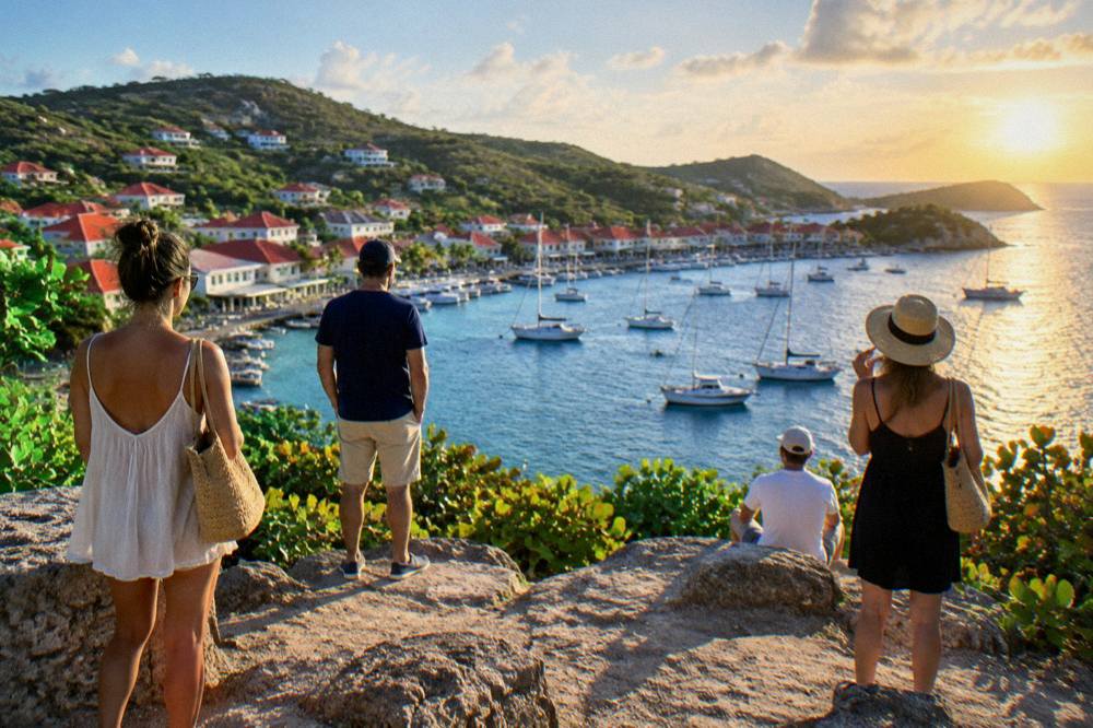 People standing freely on a public headland in Gustavia watching the sunset over the Caribbean