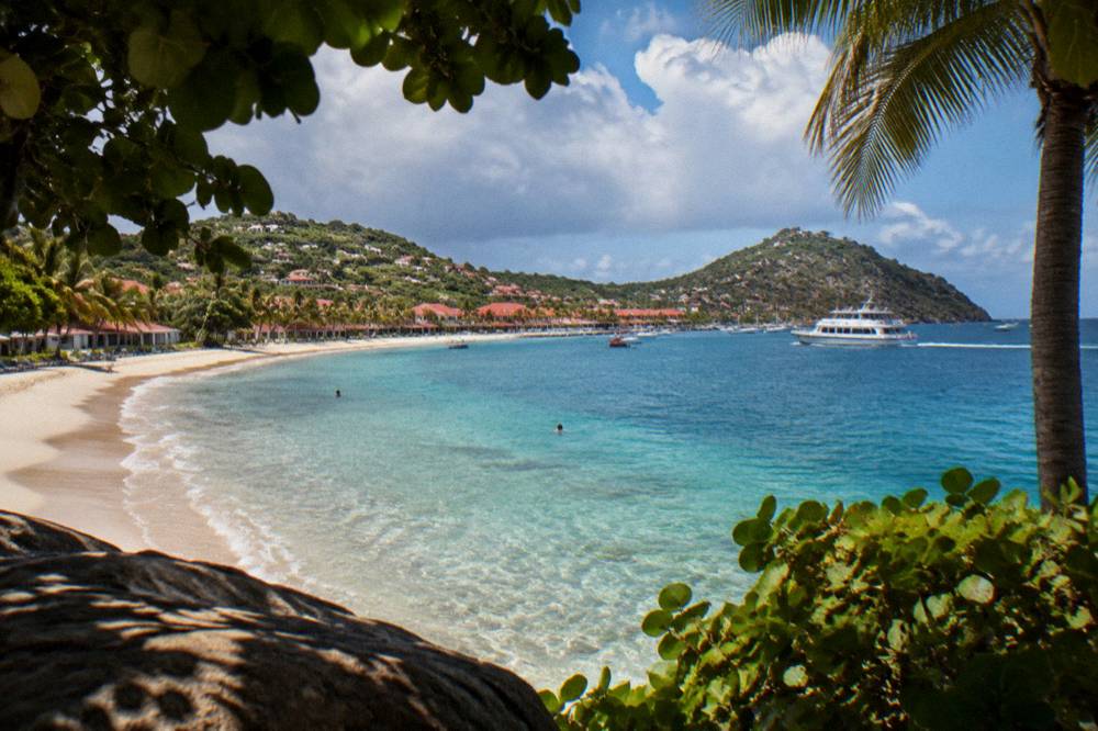 A passenger ferry crossing open blue water toward an island coastline