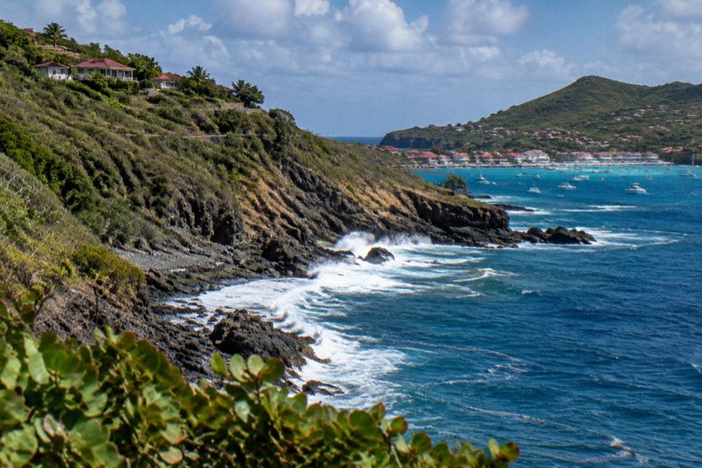 Morning light on a green headland above deep blue water