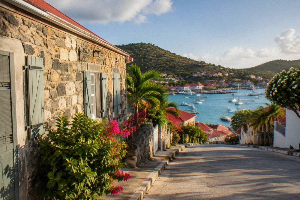 An old stone facade with shutters on a quiet street in Gustavia