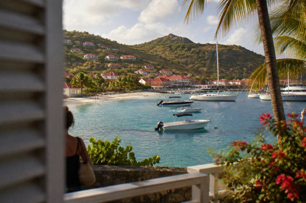 A white sand beach with turquoise water and green headlands in St Barts