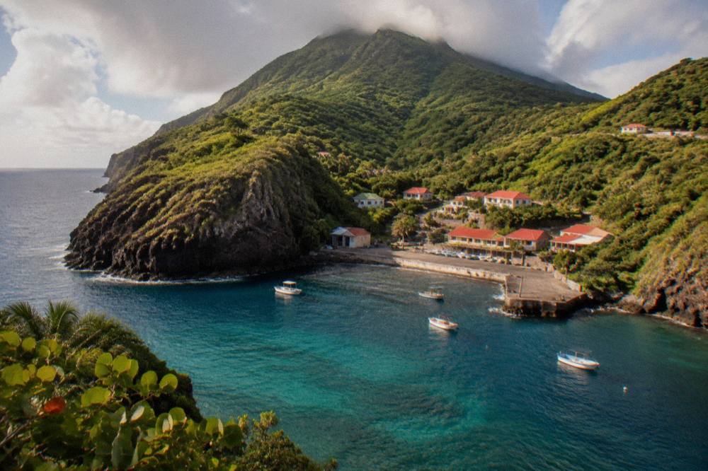 Steep forested slopes of a small volcanic island seen from the water