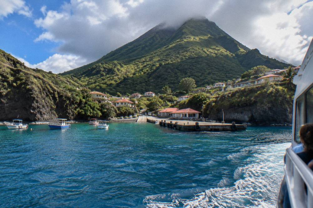 Passenger ferry approaching a small Caribbean ferry dock in morning light