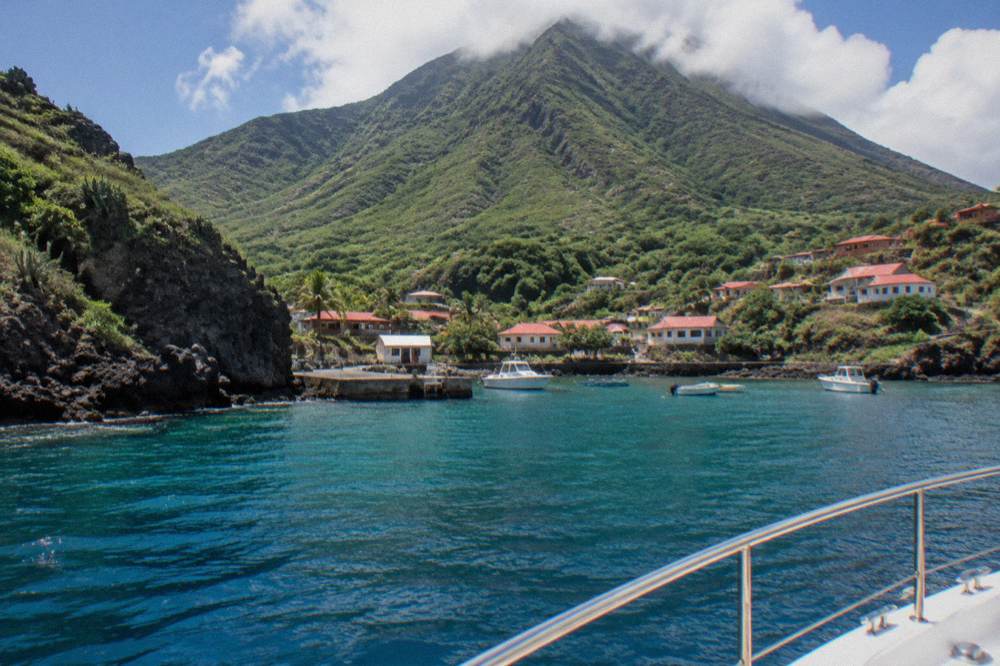 Crewed motor yacht cruising along a green island coastline
