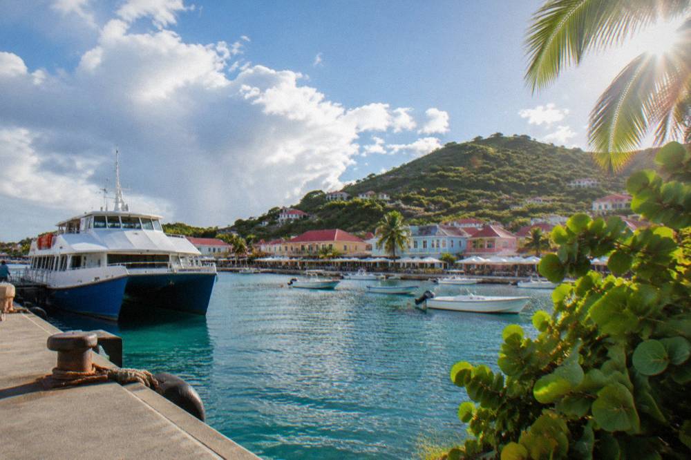 Passenger ferry docked at a small Caribbean harbour town with colourful buildings