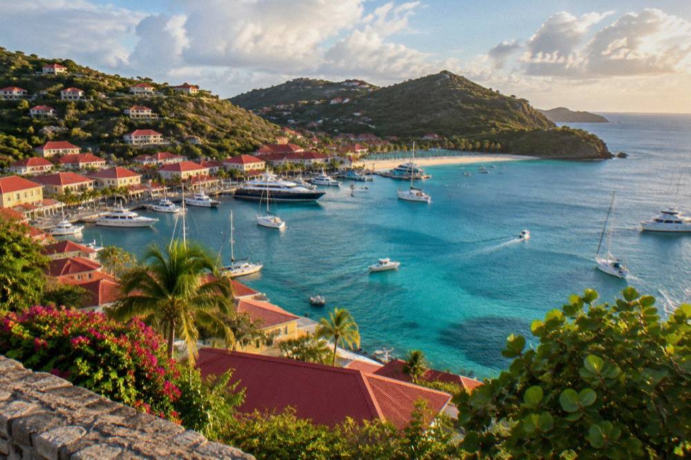 A curved Caribbean bay with turquoise water, white sand and green headlands