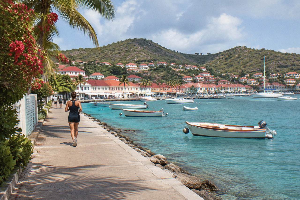 Wooden boats moored in turquoise water below green hills on a Caribbean island coastline