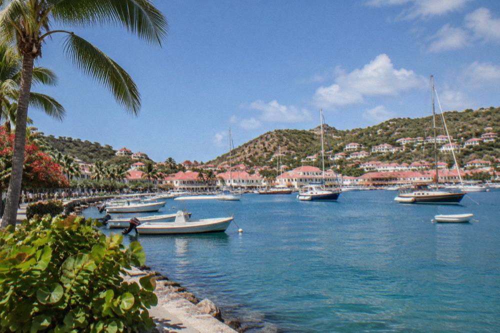 Red-roofed houses and sailboats along a small Caribbean harbour waterfront
