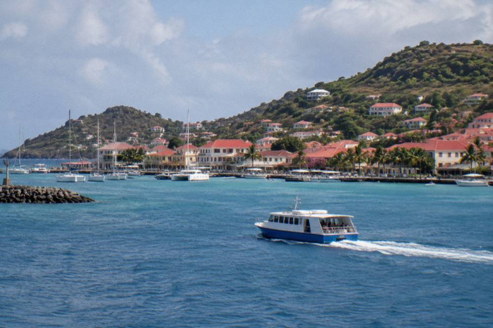 A ferry crossing open blue water between islands in the Caribbean