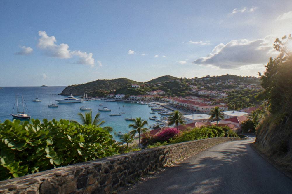 A quiet hillside road winding toward a bay on St Barts