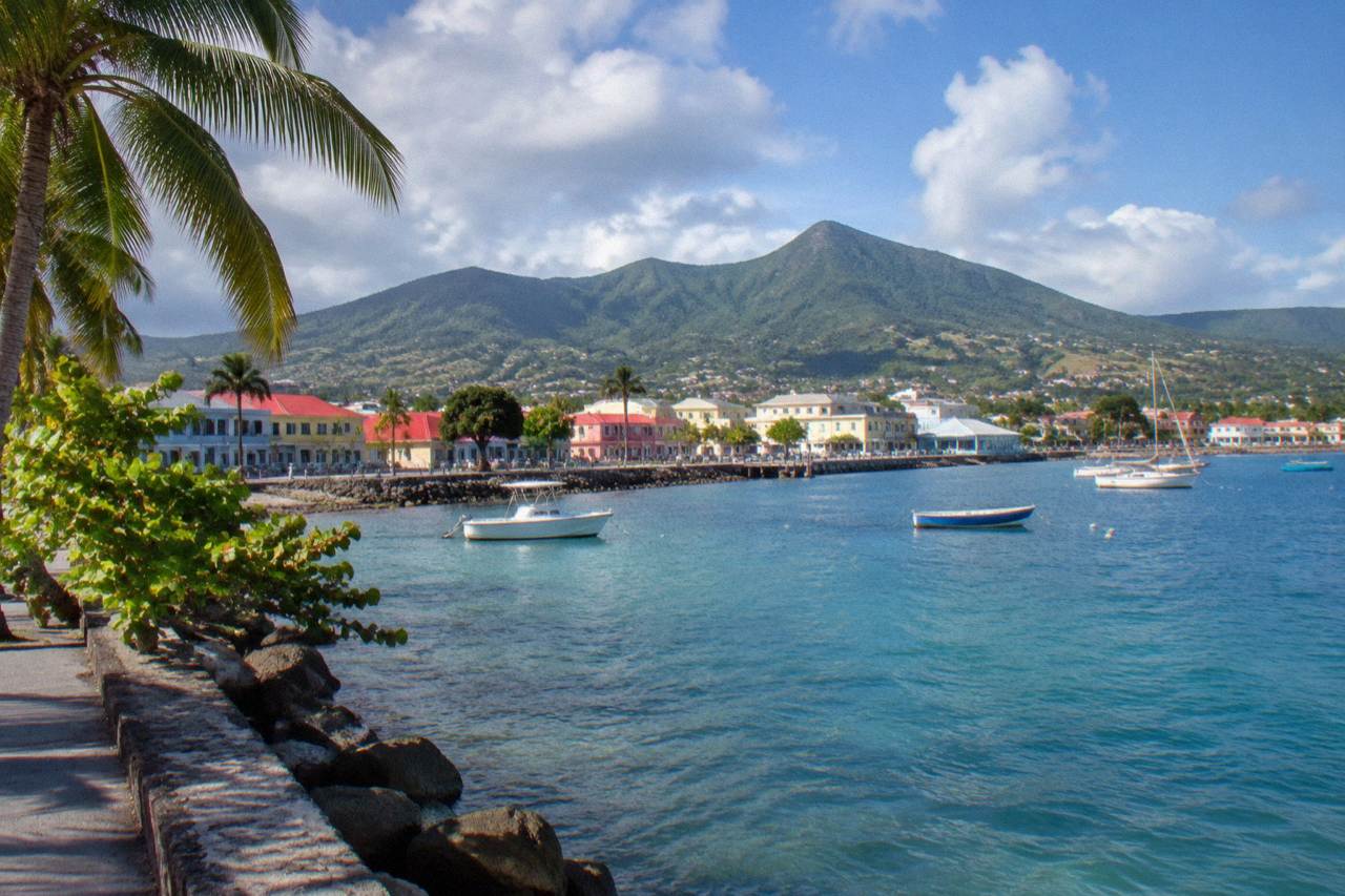 A calm Caribbean anchorage with green hills rising behind a small harbour town