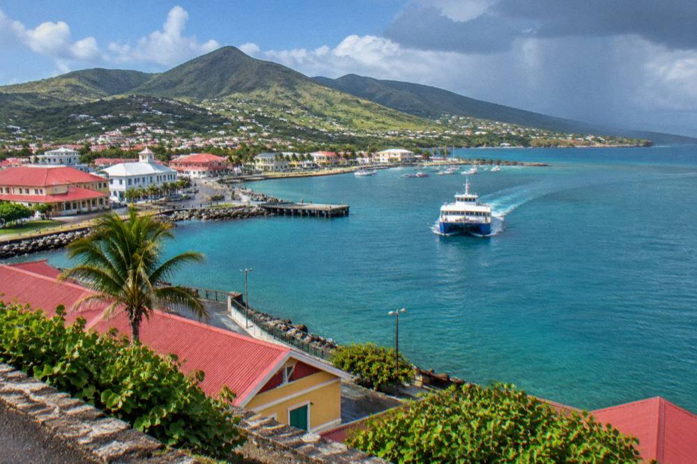 A ferry boat approaching a small Caribbean harbour with hills behind it