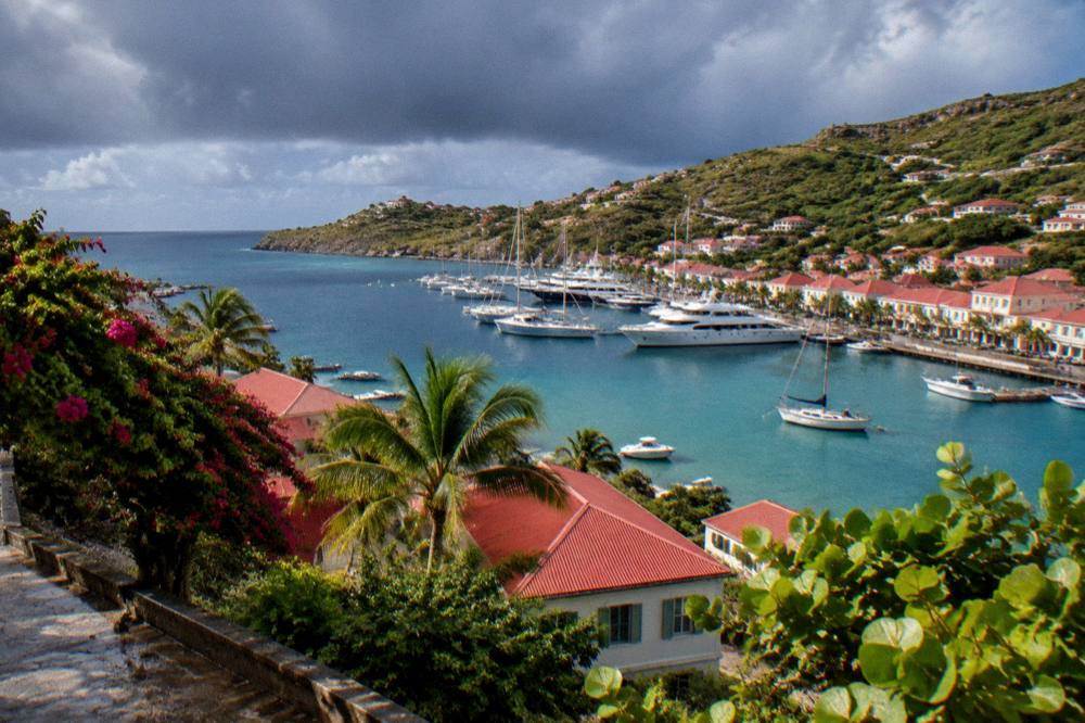Dark rain clouds over a green Caribbean hillside and sea