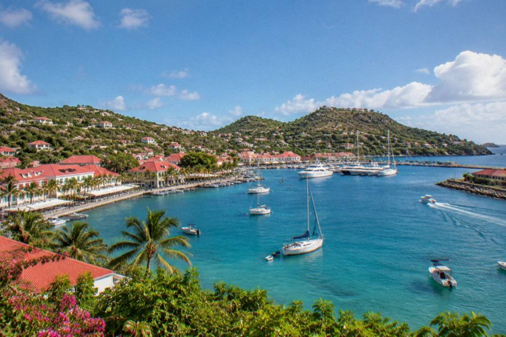 An aerial view of a turquoise channel between two green Caribbean islands